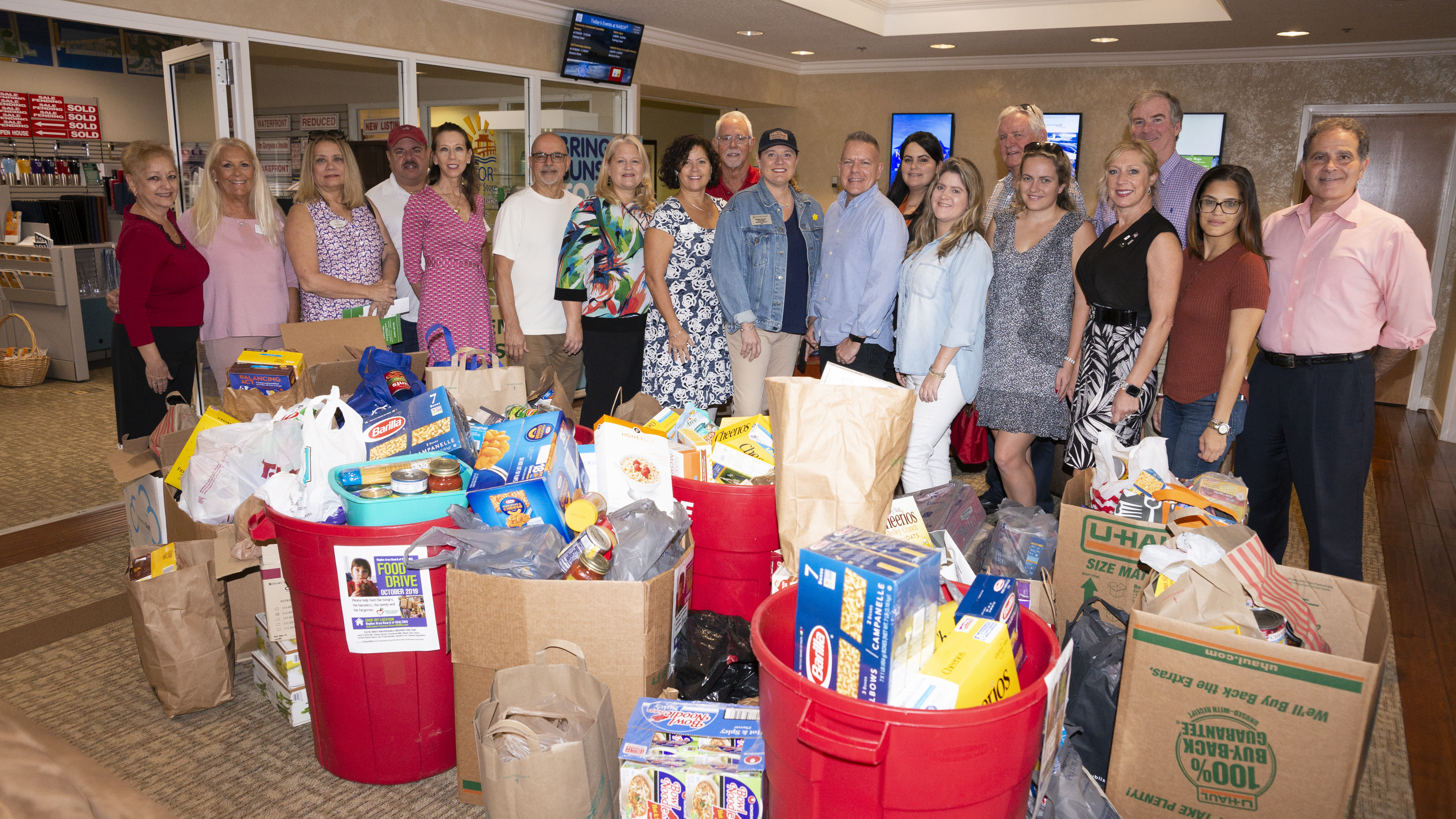 People standing in front of food drive colllection